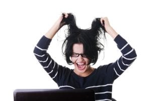 Frustrated woman working on laptop, isolated on white